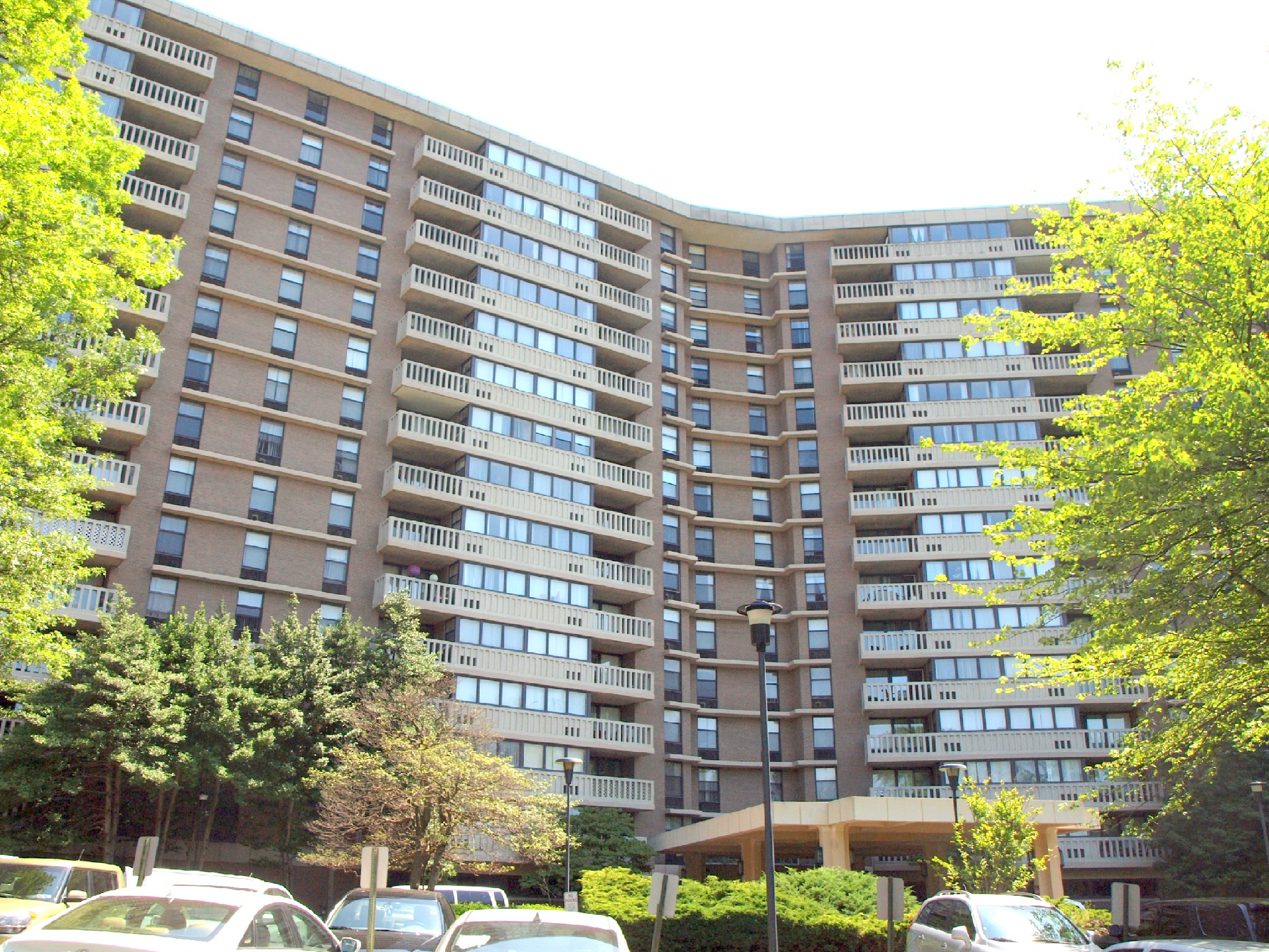 Exterior of building showing parking spaces and balconies.